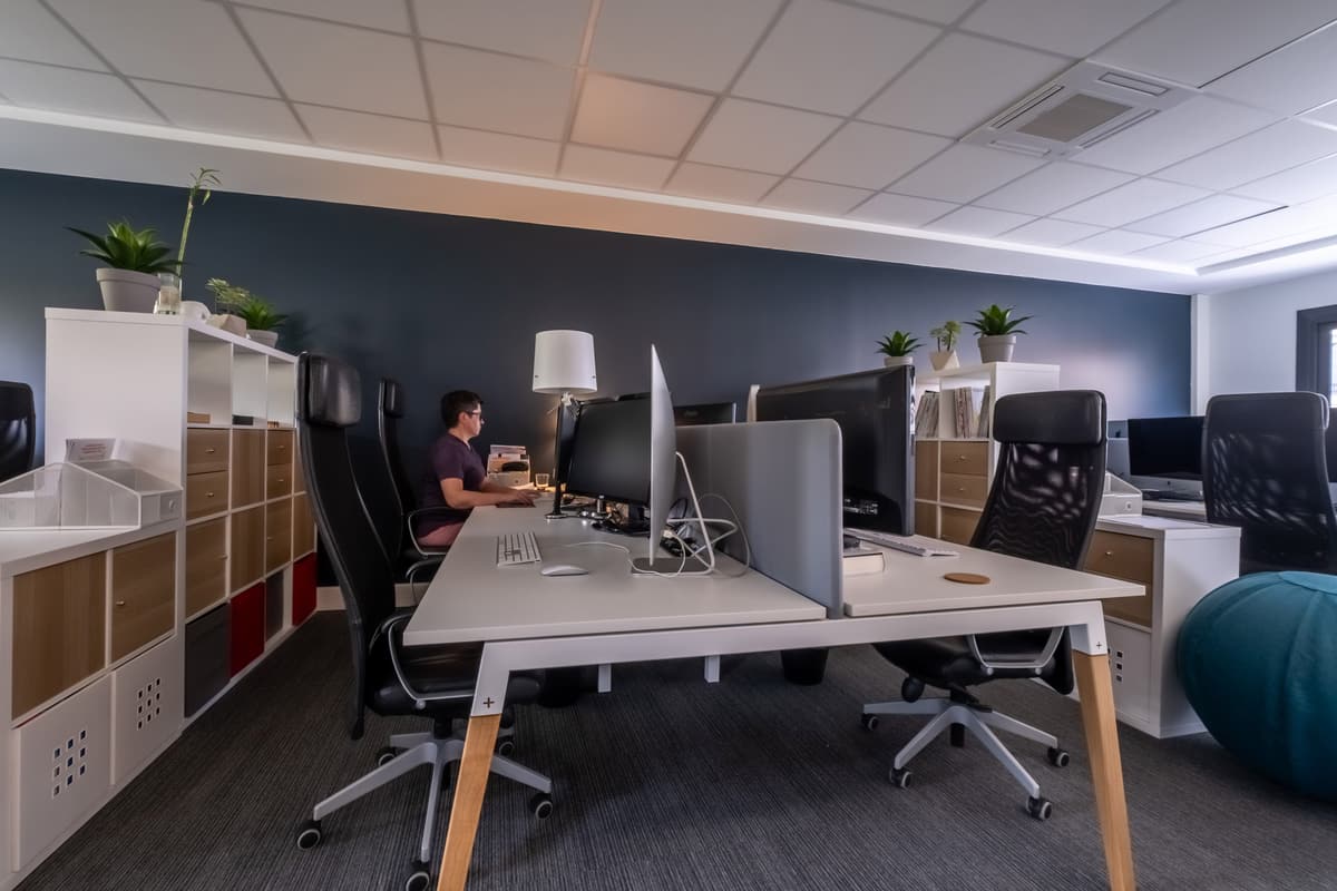 Postes de travail équipés d'un écran dans l'open space climatisé de BigFive Coworking